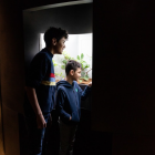 Deux jeunes regardent des insectes dans un vivarium.